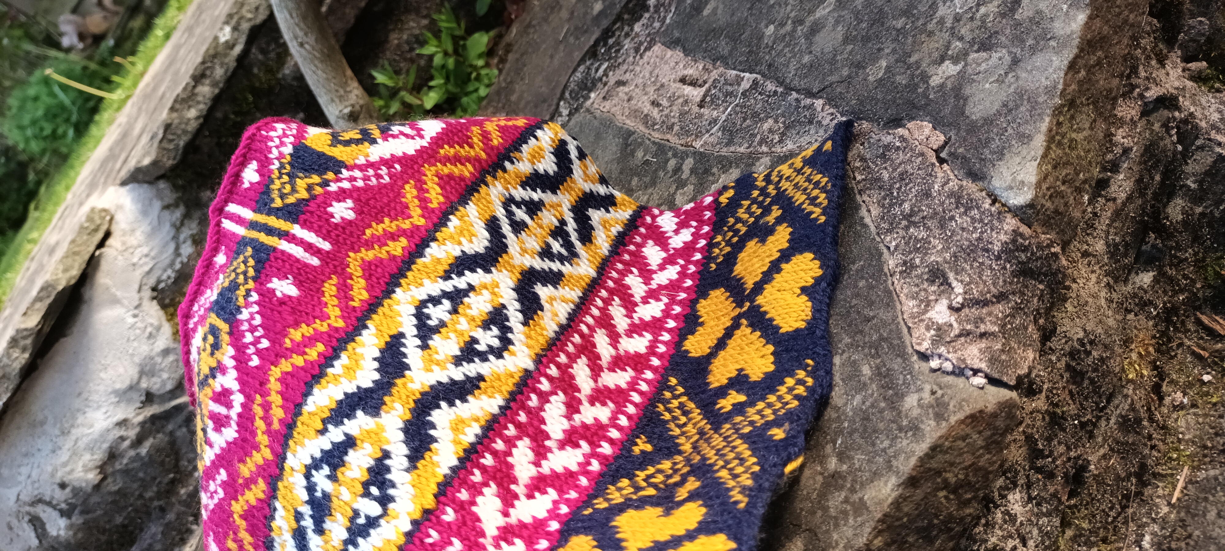 Close-up of pink, navy, white and gold Fairisle knitting