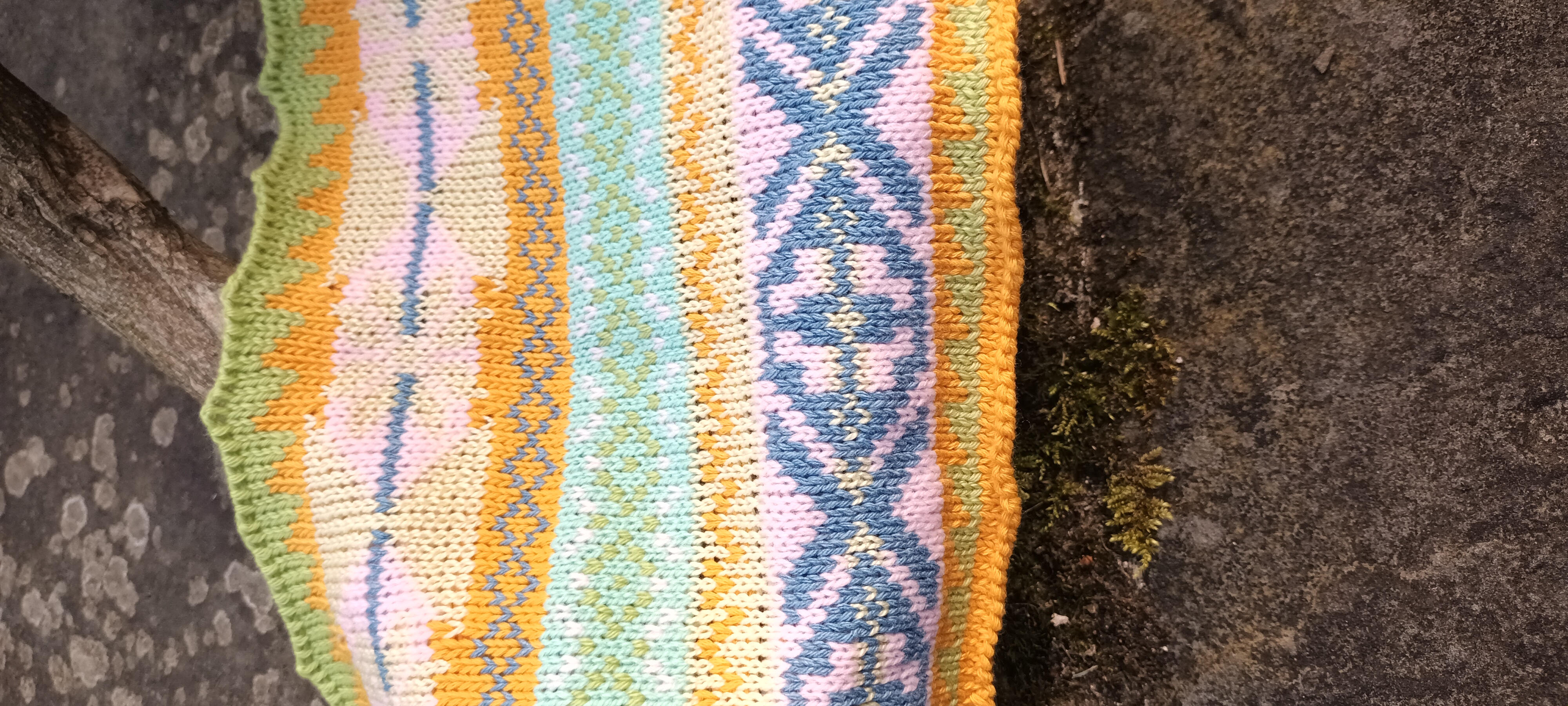 Pastel Fairisle knitted sample with green, orange, blue and pink pattern bands