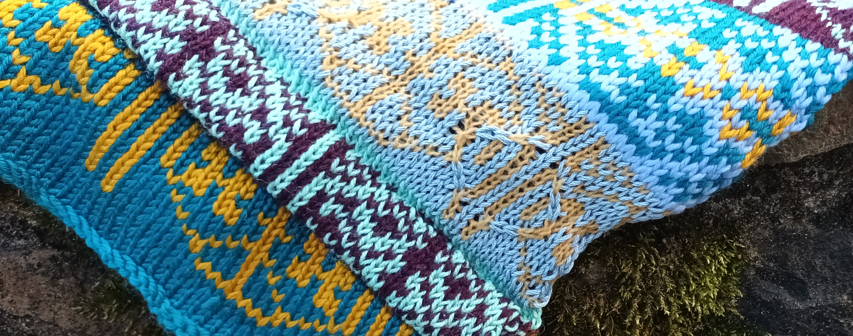 Close-up of blue, teal, gold and purple Fairisle knitting
